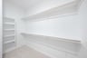 primary bedroom closet with carpet and white shelves