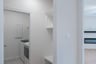 mudroom with wood floors and white shelves with bench