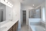 primary bathroom with two sinks and tile floors