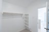 primary bedroom closet with carpet and white shelves