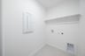 laundry room with tile floors and white shelf