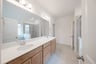 primary bathroom with two sinks and tile floors