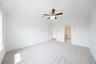 primary bedroom with carpet and ceiling fan