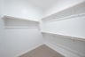 primary bedroom closet with carpet and white shelves