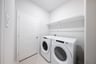 laundry room with tile floors, washer, and dryer