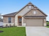 home with brick, windows and landscaped grass