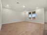 great room with brown flooring, two windows and sloped ceiling