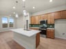 kitchen with brown flooring, brown cabinets and pendant lighting 