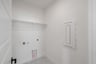 laundry room with tile floors and white shelf