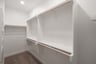 primary bedroom closet with carpet and white shelves