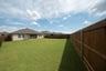 covered patio that opens up to large fenced backyard 