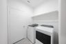 laundry room with tile and white shelves