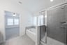 primary bathroom with shower and brown cabinets