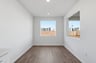 dining room with wood floors, white walls, and two windows