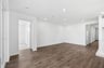 great room with wood floors, white walls, recessed ceiling lights, and view of entry foyer