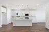 kitchen with white cabinets, white quartz counters, center island, wood floors, and window