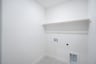laundry room with tile floors and white shelf