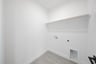 laundry room with tile flooring and shelf 
