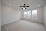 bedroom with large windows and ceiling fan 