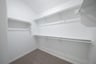 primary bedroom closet with carpet and white shelves
