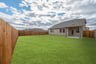 large fenced backyard with covered patio 
