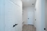 mudroom with wood floors and white shelves with bench