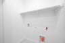 laundry room with tile floors and white shelf