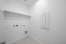 laundry room with tile floors and white shelf
