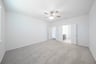 primary bedroom with carpet and ceiling fan