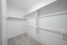 primary bedroom closet with carpet and white shelves