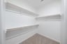 primary bedroom closet with carpet and white shelves