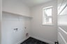 laundry room with tile floors and white shelf