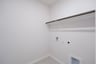 laundry room with tile floors and white shelf