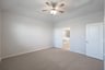 primary bedroom with carpet and ceiling fan