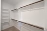 primary bedroom closet with carpet and white shelves