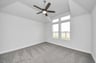 high ceilings with fan and carpeted flooring