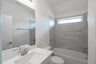 bathroom with tub and white countertops 