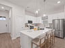 kitchen with quartz countertops, white cabinets and pendant lighting