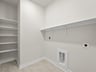 laundry room with white floor and white shelving