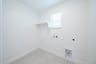 laundry room with tile floors and white shelf