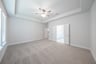 primary bedroom with carpet and ceiling fan