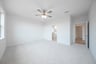 primary bedroom with carpet and ceiling fan