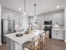 Kitchen with brown floors, quartz countertops and pendant lighting