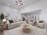 great room with brown flooring, ceiling fan and decor