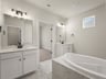 bath with two sinks, white floor and soaking tub