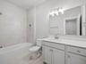 bathroom with quartz countertops and a bathtub 