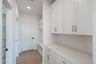 Mudroom next to butler's pantry with wood flooring 