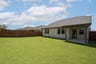 covered patio that opens up to fenced backyard 