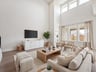 great room with ceiling fan, windows and brown flooring