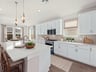 Kitchen with quartz countertops, pendant lighting and white cabinets